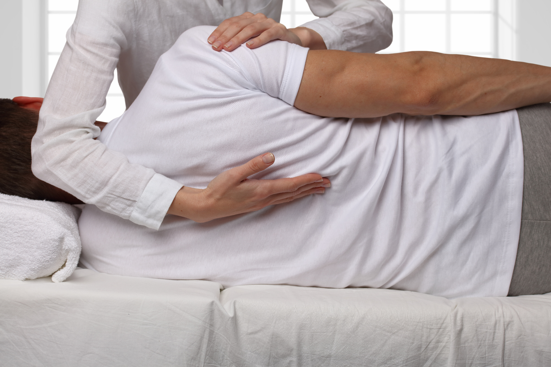 Chiropractor performing a side-lying spinal adjustment on a relaxed patient